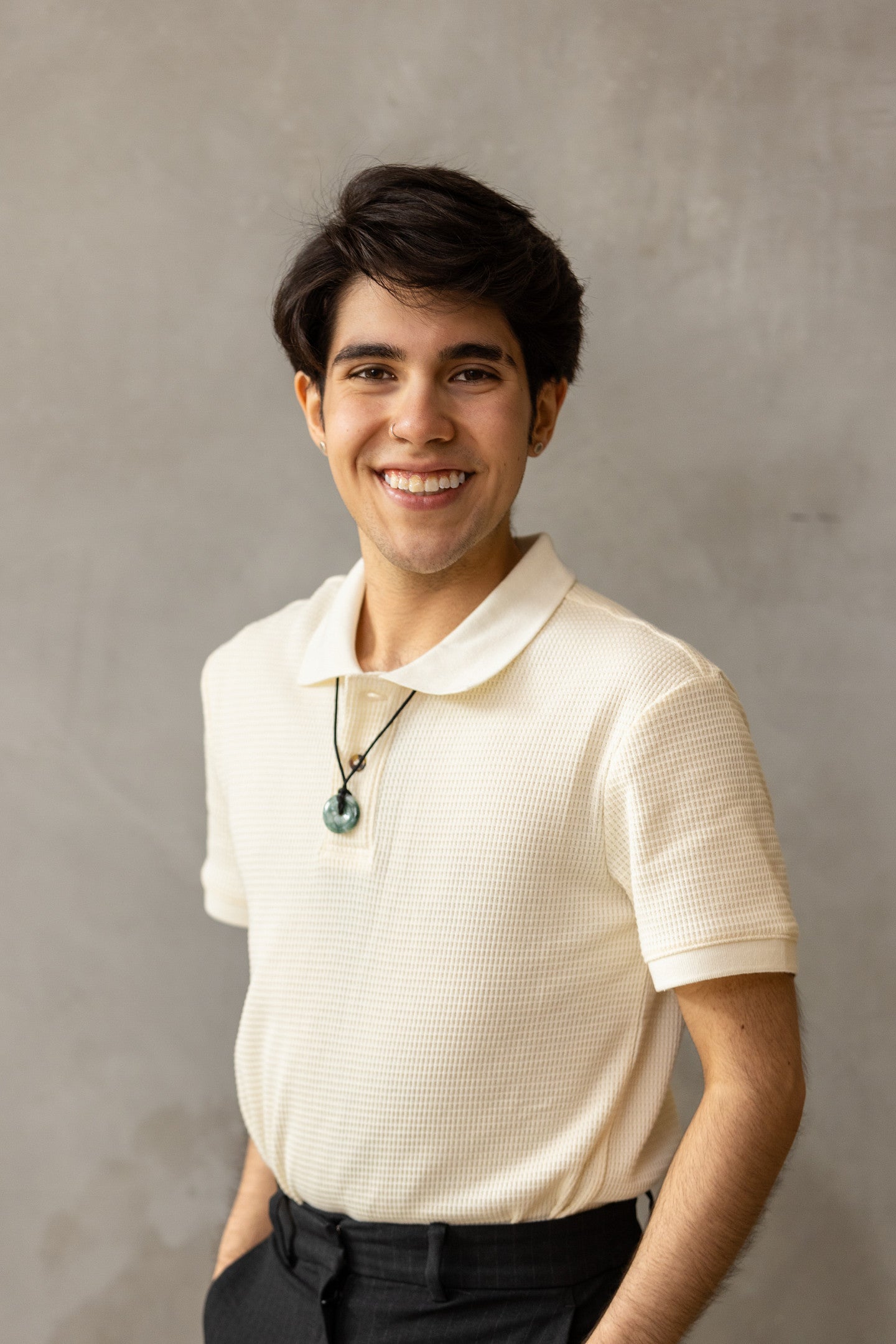 Photograph of Jonah Gomez Cabrera. Shows a smiling individual in a white shirt and short hair. 
