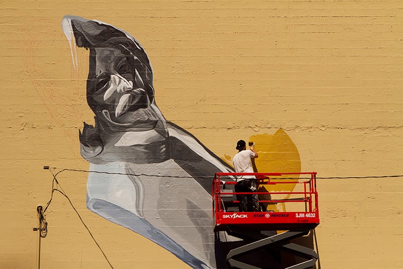 Hamilton painting his mural as part of the Forest For The Trees project.