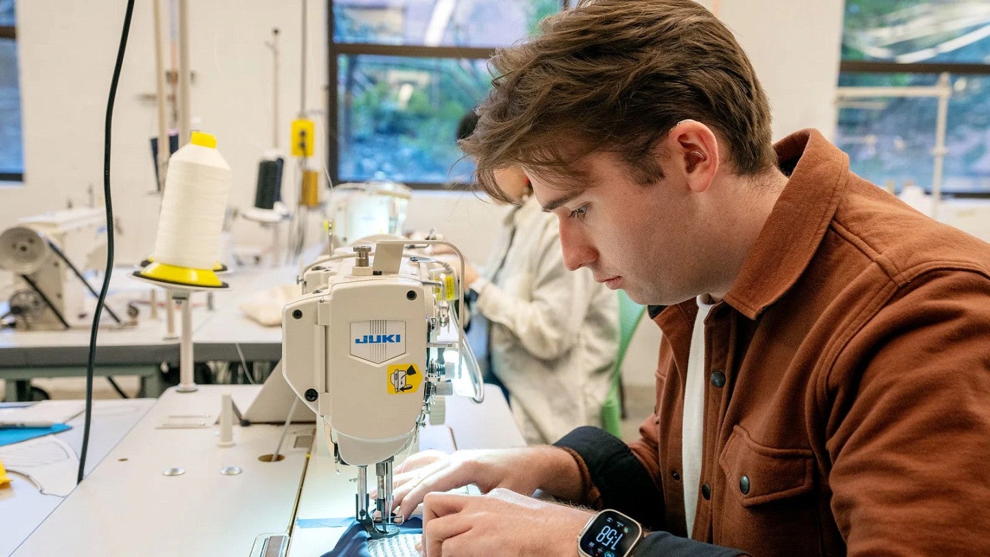 Photograph of Eli Mikiten sewing in a product design class.