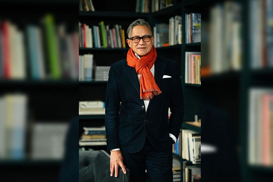 Photograph of Gene Sandoval in front of a library.