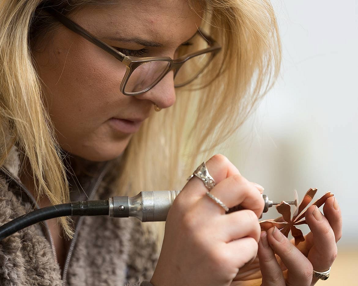 student polishes metal object