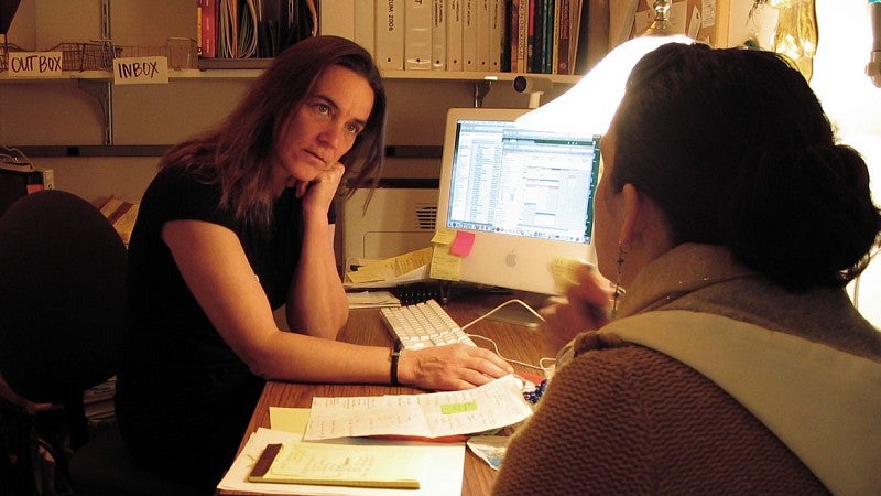 Kassia Dellabough talks with student at desk