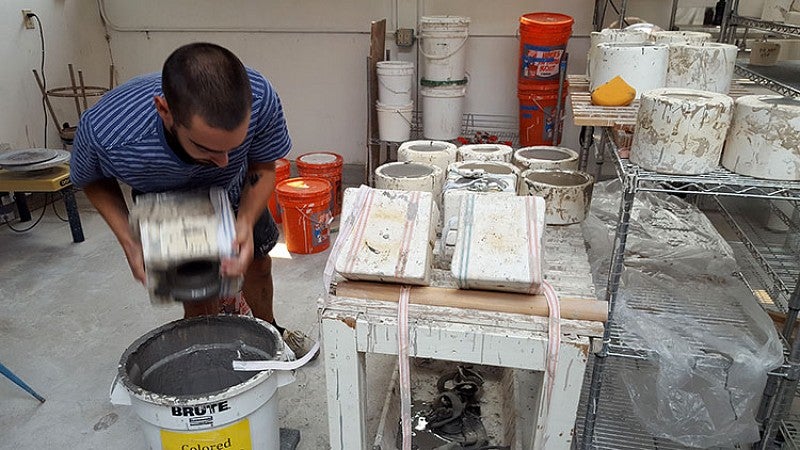 Thomas Sprott pours excess slip from a mold. Photo by Marti Gerdes.