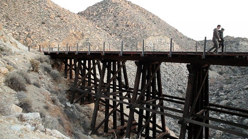 two people walk on train trestle