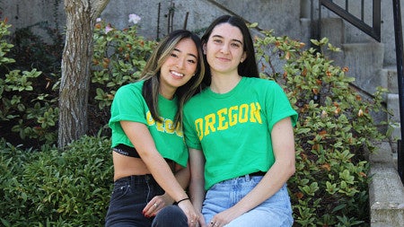 Kiera and femal friend posing in front of a bush