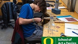 Photograph of a student working on jewelry. 