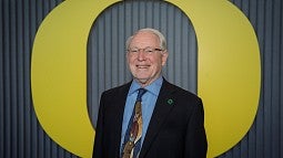Photograph of Larry Bruton in front of the University of Oregon "O" on the Portland campus. 