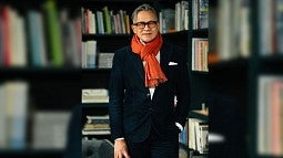 Photograph of Gene Sandoval in front of a library. 