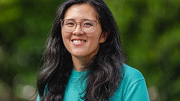 Nicole Ngo news header for story. Shows a portrait of a woman in front of a blurry green background. Decorative. 