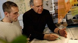 Phot of Otto Poticha with a student at his desk