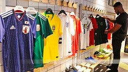 person looks at soccer jerseys on display