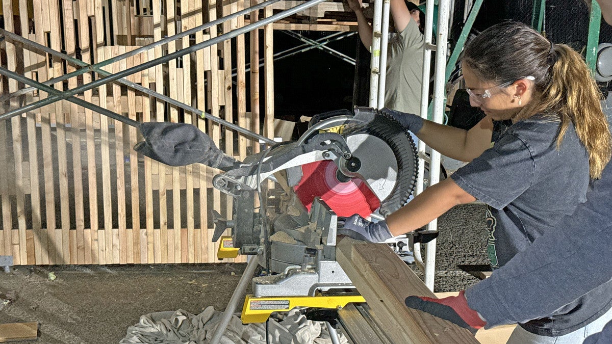 BDI student cutting lumber. 