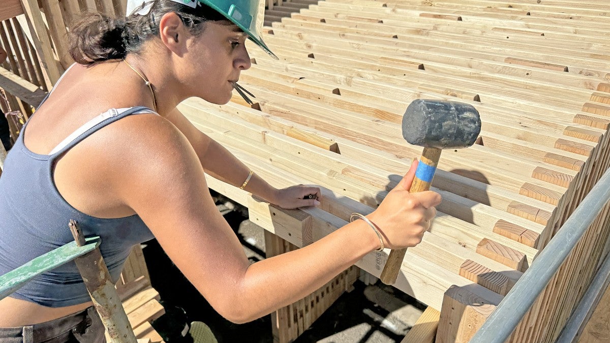 BDI student hammering the roof into place