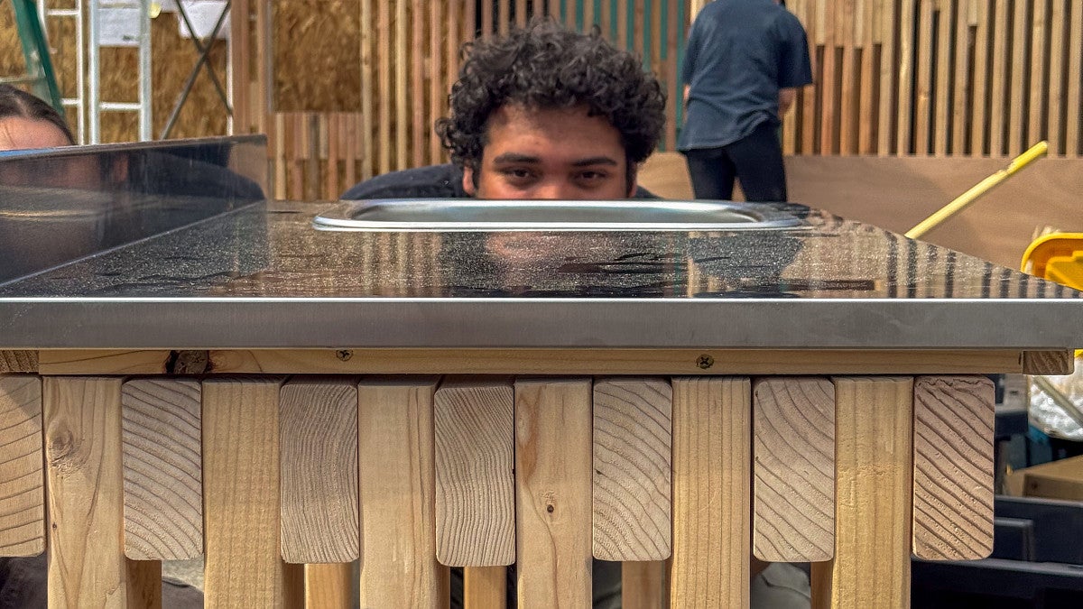 Photograph of a student that is inspecting a sink before installation.