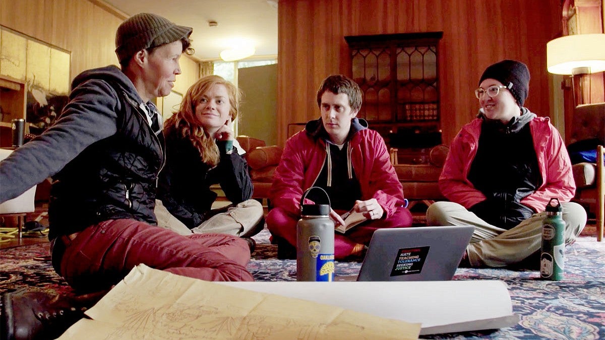 Students and professor sitting on floor of home