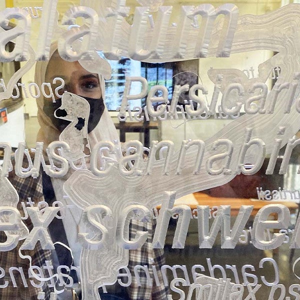 Up close shot of one of Kyuho's students behind the transparent pillar. The artwork in the pillar signifies endangered species, while the transparency show that humans have a role in our ecosystems.