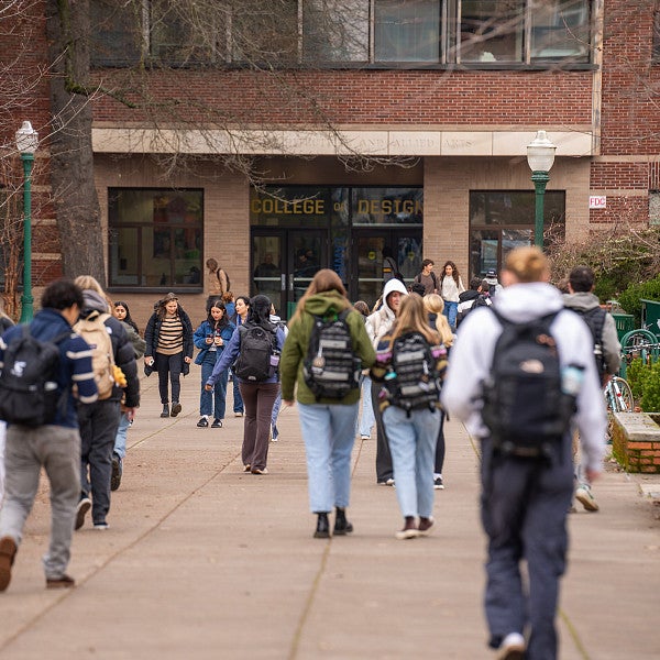 Photograph of students walking into Lawrence Hall. 