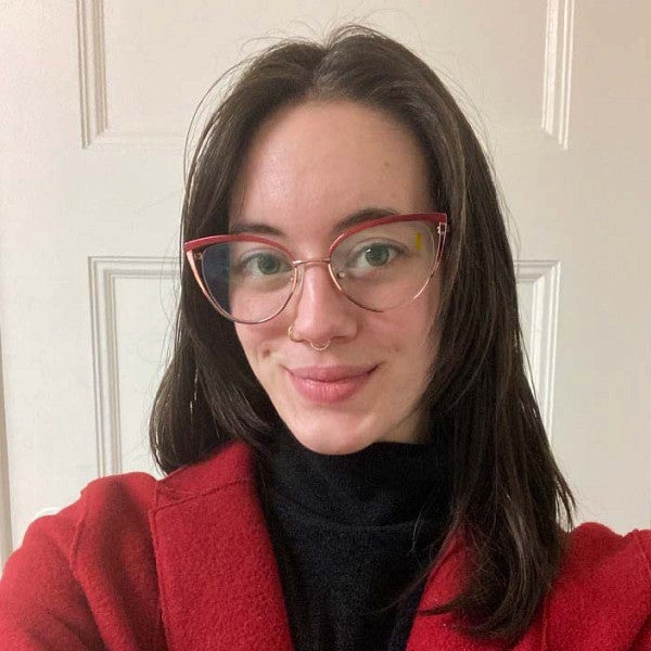 Photograph of a woman in glasses smiling into the camera. 