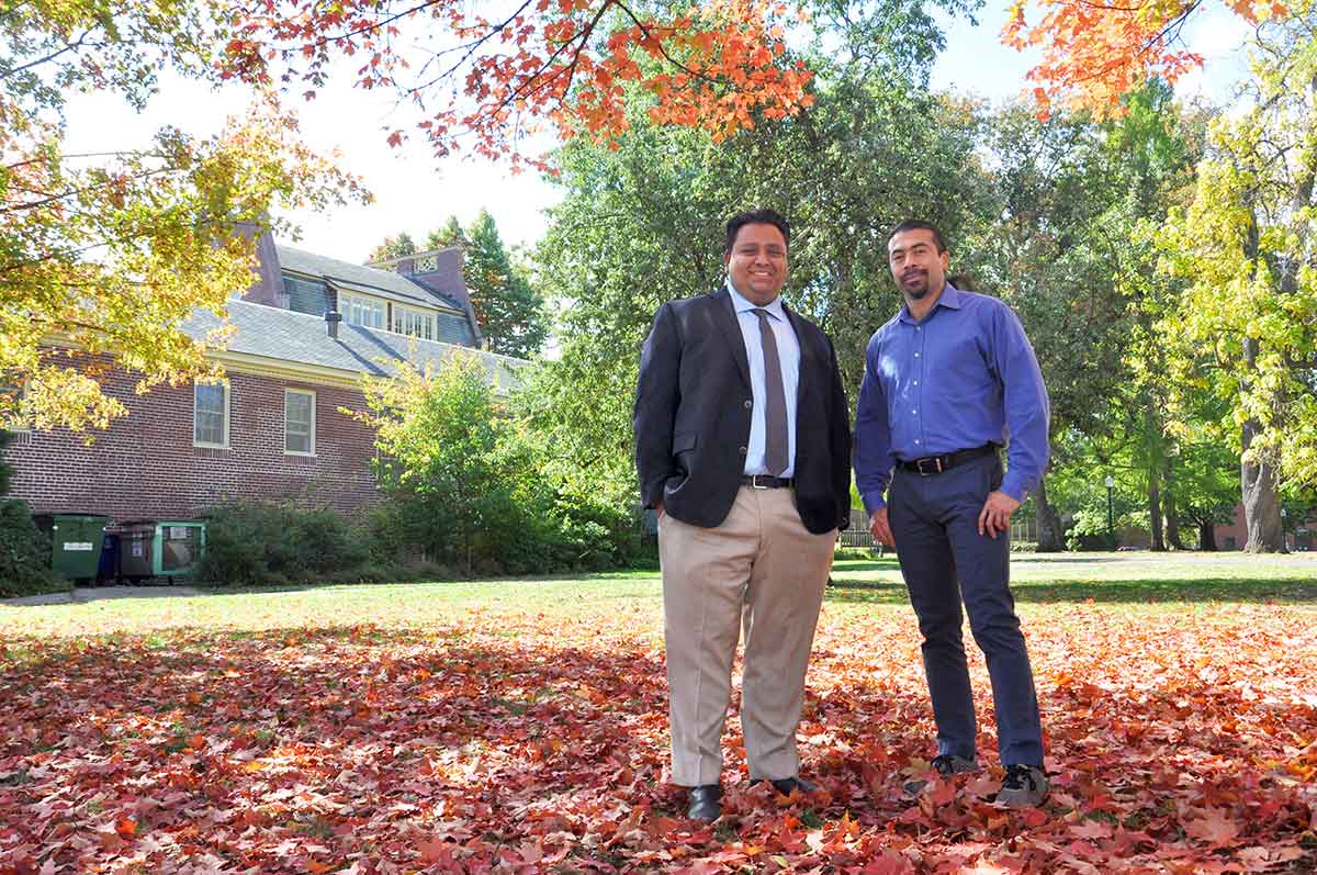 Two men standing under an autumn tree