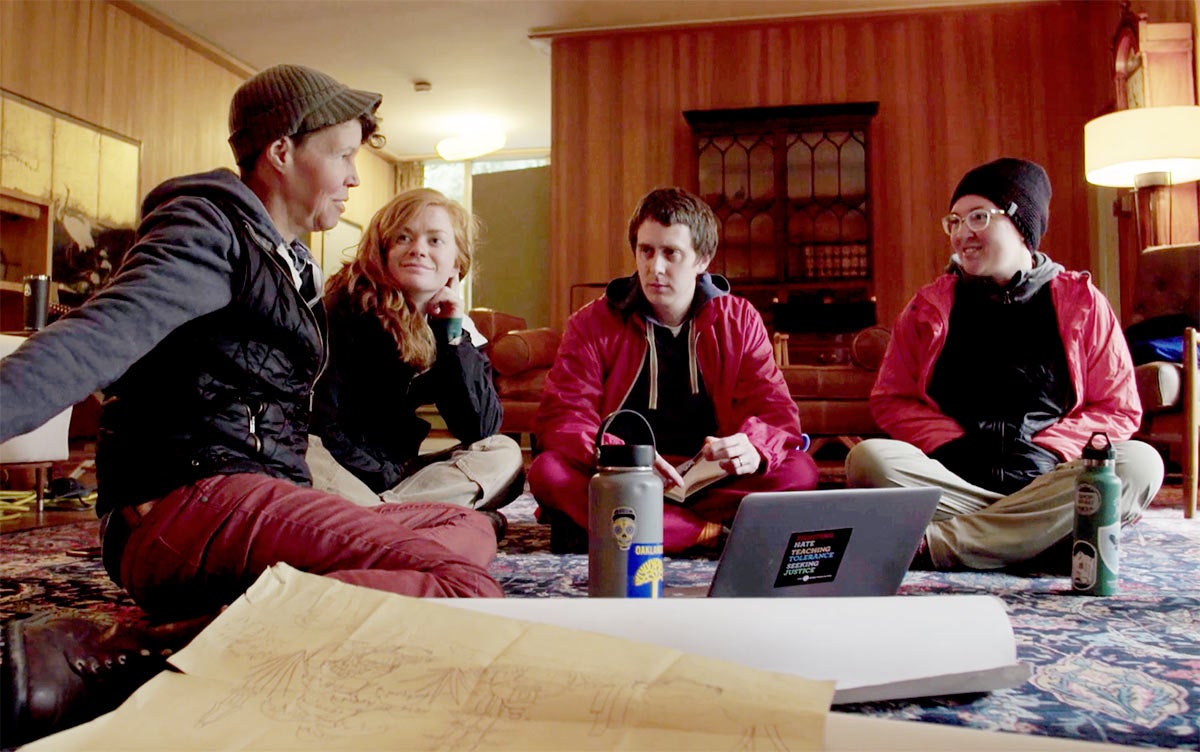 Students and professor sitting on floor of home