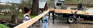 people loading lumber onto flatbed truck