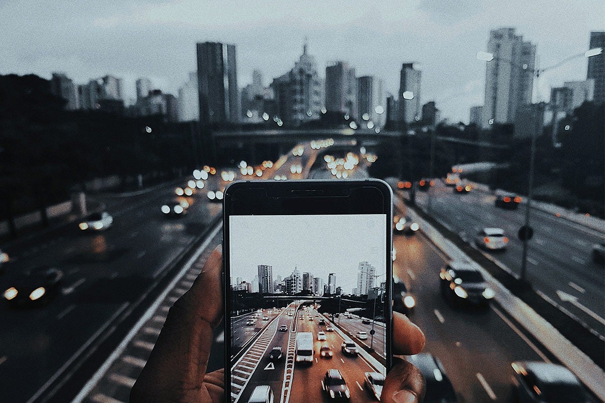 Photo of a phone looking at a cityscape and traffic