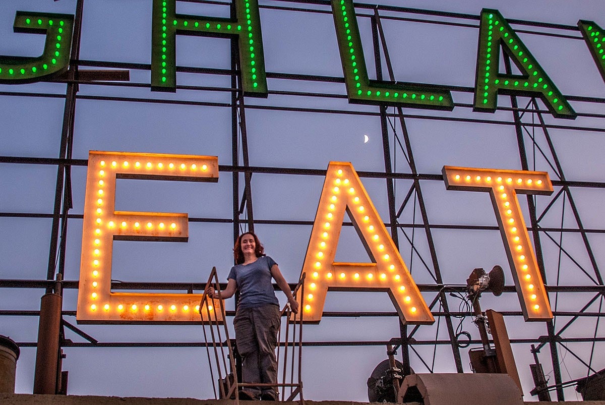Photo of Nicole Possert with an historic neon sign