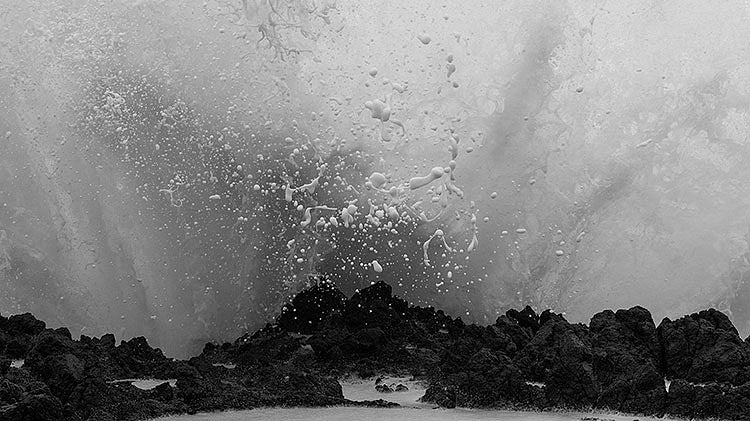 photo of wave splashing on rocks, by Ron Jude