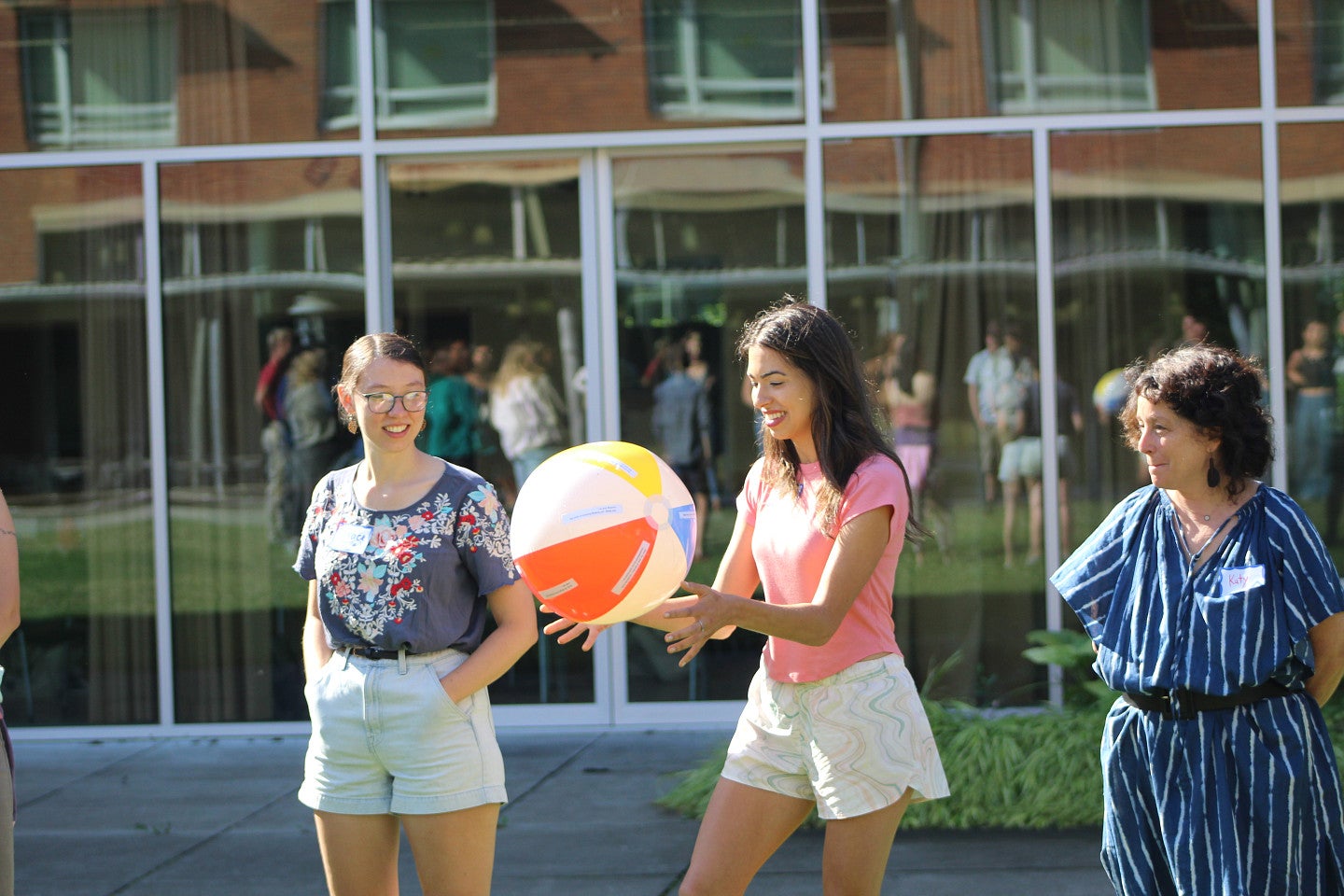 RARE cohort come together outside for a team building exercise that includes a beach ball. Three individuals are pictured. 