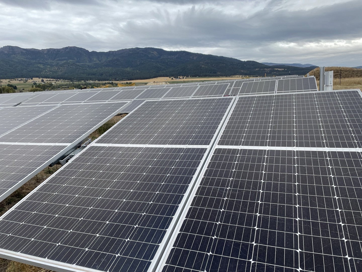 Photograph of solar panels in front of a landscape of hills
