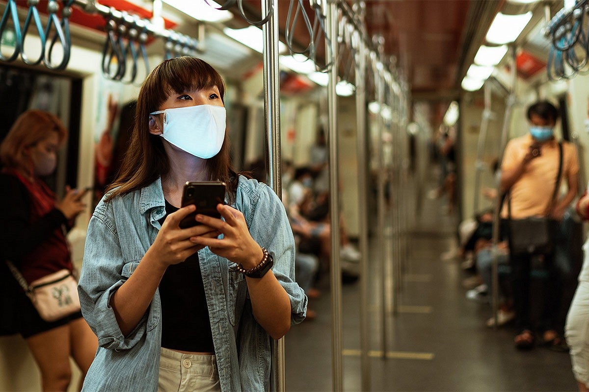Women in mask with others in the subway