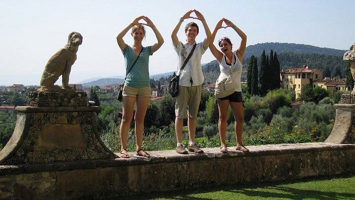 three students make O with hands while visiting Rome