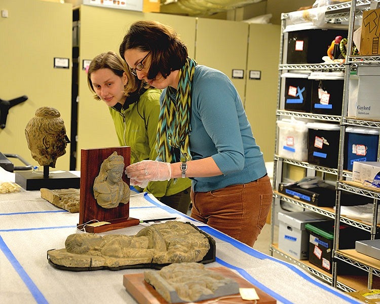 two people inspect sculptural artifacts at the Jordan Schnitzer Museum of Art