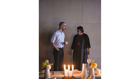Two people standing at candle lit table