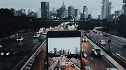 Photo of a phone looking at a cityscape and traffic