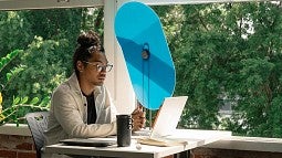photo of a person at a desk with a task shade