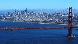 Photo of the San Francisco skyline from Wikipedia. Features water, the Golden Gate bridge, and numerous buildings.