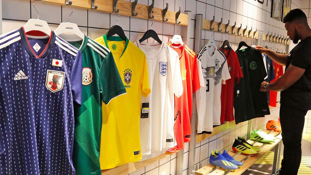 person looks at soccer jerseys on display