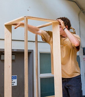 Trent working on a wooden frame for a transpecies design project